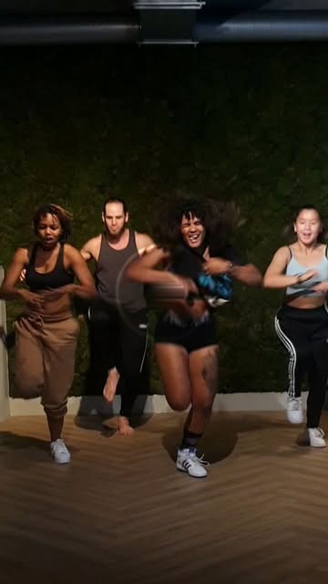 Een groep danst samen in een donkere dansruimte