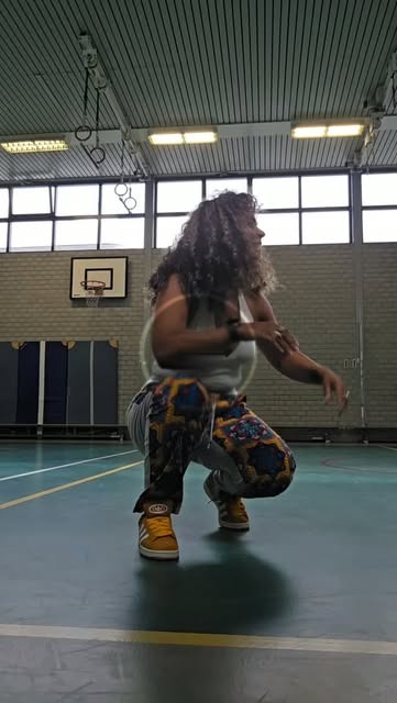 Mel danst salsaton in een sportzaal
