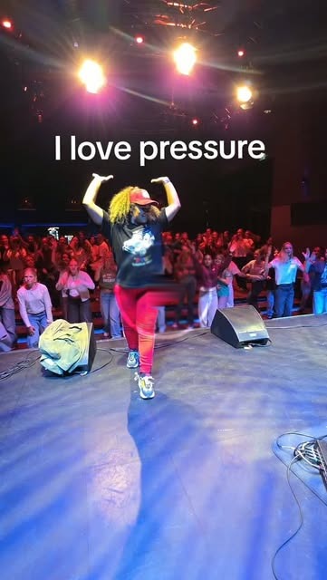 Mel geeft een dansworkshop op een podium aan een grote groep