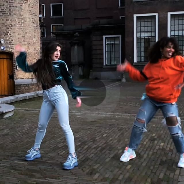 Twee danseressen dansen op een pleintje